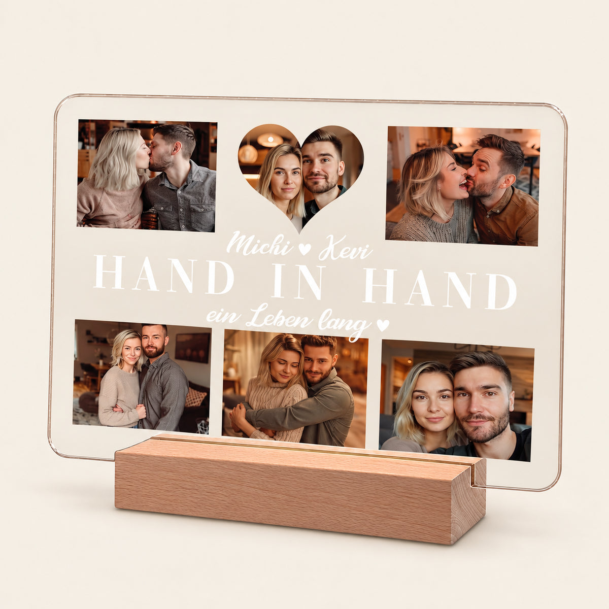 Personalisierte Acryl-Fotocollage auf einem Holz-LED-Sockel mit 5 Paarfotos und einem herzförmigen zentralen Foto. Weißer Text lautet 'Michi Kevi HAND IN HAND ein Leben lang' mit kleinen Herzakzenten.
