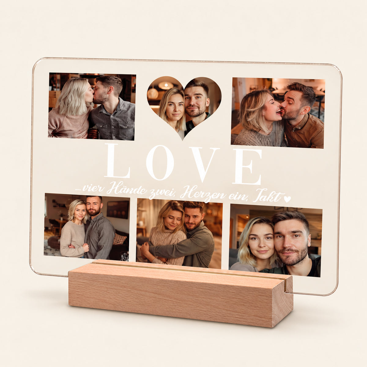Beleuchtete Acryl‑Foto‑Collage‑Anzeige auf einem hölzernen LED‑Ständer, mit 6 Paar‑Fotos rund um ein herzförmiges Mittelbild. Weißer Text lautet „LOVE“ und „…vier Hände zwei, Herzen ein, Takt“ mit einem kleinen Herz.