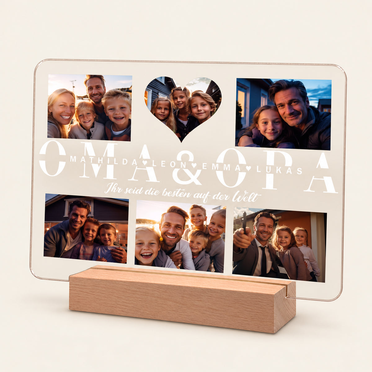 Personalisierter Acryl-Fotodisplay auf einem hölzernen LED-Sockel mit sechs Familienfotos und einem herzförmigen Ausschnitt. Der Text lautet „OMA & OPA“ mit den Namen „Mathilda, Leon, Emma, Lukas“ und dem deutschen Satz „Ihr seid die besten auf der Welt“