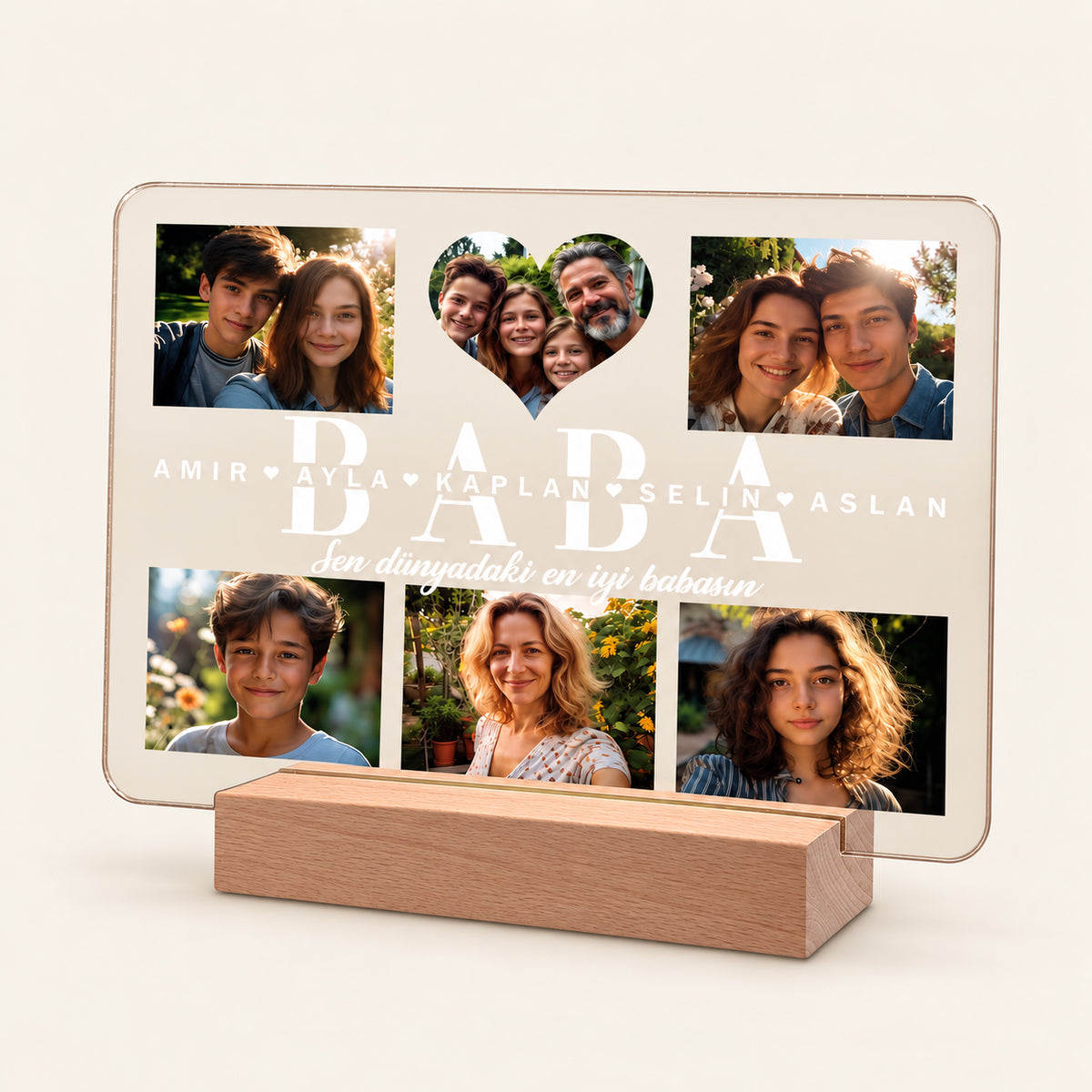 Personalisierte Acryl-Fotionachtlampe auf einem hölzernen LED-Sockel, die sechs Familienfotos und ein herzförmiges zentrales Foto zeigt. Der Text lautet „BABA“ mit den Namen Amir, Ayla, Kaplan, Selin, Aslan und dem Satz „Sen dunyadaki en iyi babasin“.