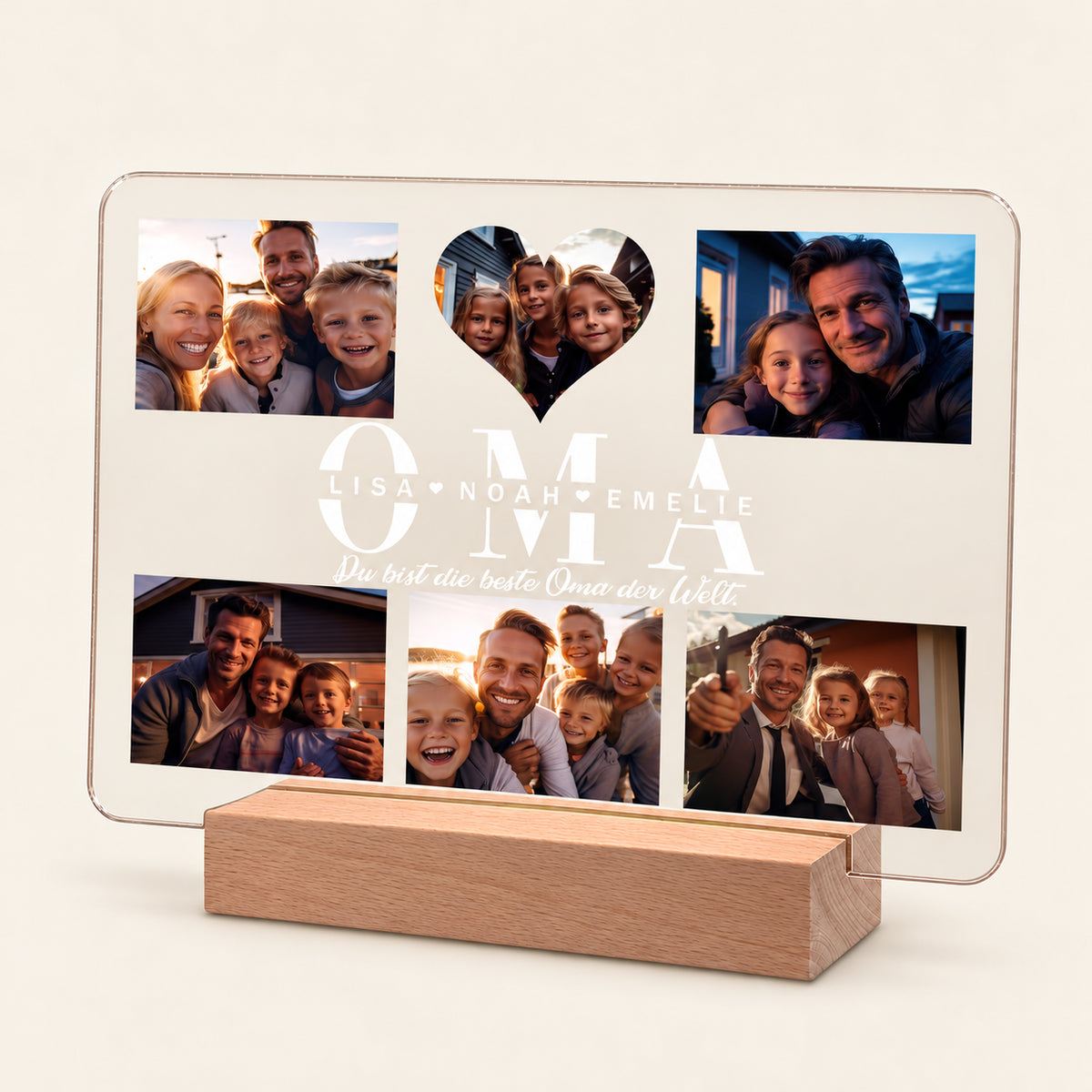Beleuchtetes Acryl-Fotodisplay auf einem Holz-LED-Sockel mit fünf Familienfotos und einem herzförmigen Ausschnitt. Der weiße Text lautet 'OMA' mit den Namen Lisa, Noah, Emelie und dem Satz 'Du bist die beste Oma der Welt.'